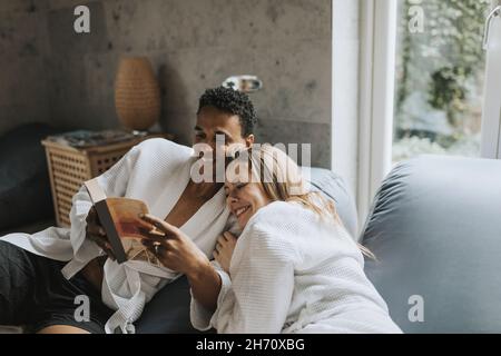 Smiling couple sitting together on sofa Stock Photo