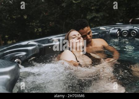 Couple relaxing in hot tub Stock Photo