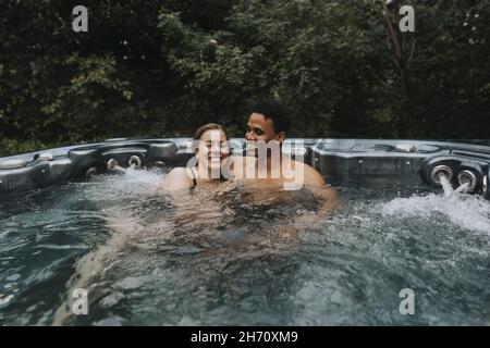 Couple relaxing in hot tub Stock Photo