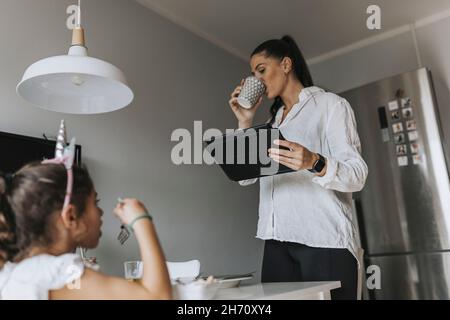 Woman using digital tablet in kitchen Stock Photo