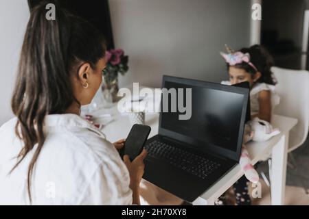 Woman working from home, girl on background Stock Photo