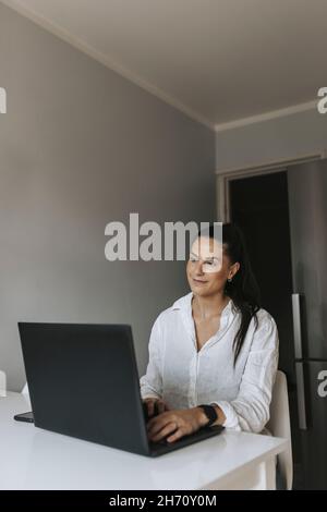 Smiling woman using laptop Stock Photo