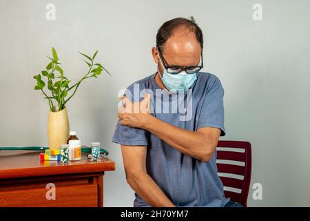 Senior man with shoulder pain. Middle-aged gentleman is in horrible pain. Neck and shoulder pain suffering from neck and shoulder injury, person with Stock Photo