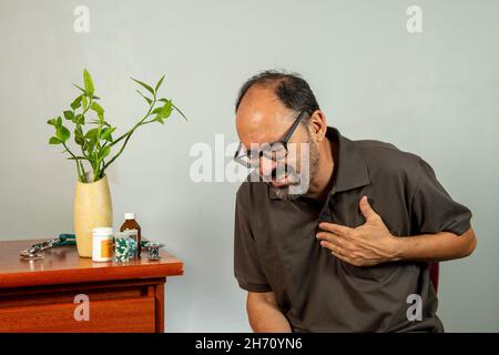 Senior man with shoulder pain. Middle-aged gentleman is in horrible pain. Neck and shoulder pain suffering from neck and shoulder injury, person with Stock Photo