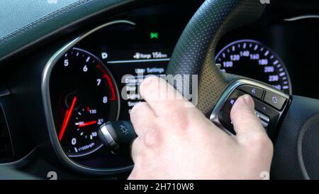Surfing in Additional car control instruments on car dashboard using modern sensor button on the wheel. Stock Photo
