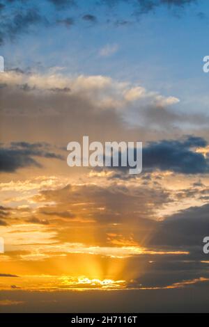 Golden rays of the sun break through clouds at sunrise to form the Tyndall Effect, Switzerland.. Stock Photo