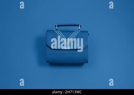 Blue fashion leather womens bag on blue background. Flat lay, top view. Copy space for your text. monochrome Stock Photo