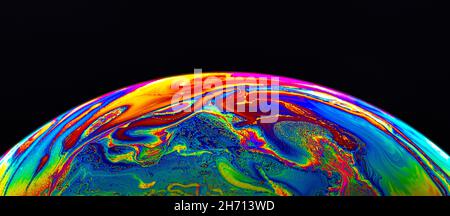 Virtual reality space with abstract multicolor psychedelic planet. Closeup Soap bubble like an alien planet on black background. Stock Photo