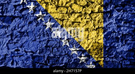 Bosnia and Herzegovina flag depicted on a stone wall. The texture of the stone blends perfectly with the colors of the banner Stock Photo