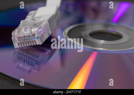 Detail of white ethernet connector RJ-45 lying on compact disc Stock Photo