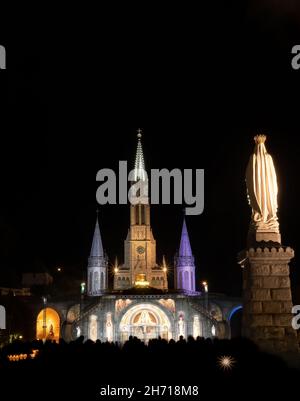 Night shot of illuminated church of Lourdes in France, the place of apparitions of virgin Mary, Stock Photo