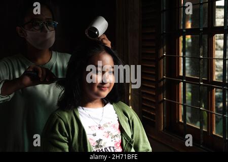 Teenage girl drying sister hair Stock Photo