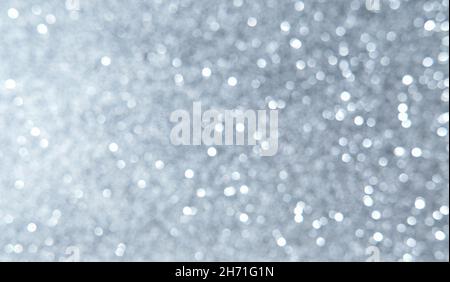 White, silver, gray Christmas background with defocused lights. Background for Valentine's Day. White or silver lights on a silver background. Stock Photo