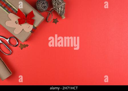 Christmas holiday flat lay composition with copy space on the right side of red a background and objects coming into the frame from the upper left cor Stock Photo