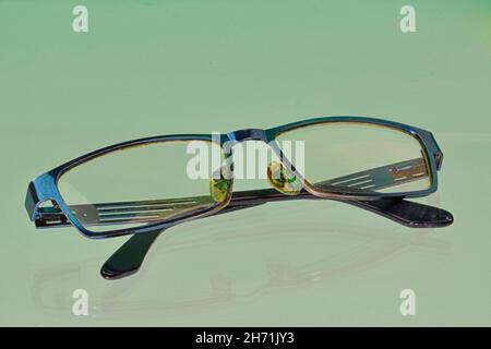 Reflection of eyeglasses. Blue eyeglasses, close-up. Eye glasses. Old style eyeglasses. Glasses with transparent lenses. Vintage Glasses on reflected Stock Photo