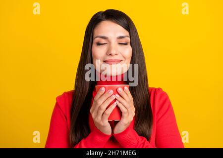 Photo of charming positive lady closed eyes hold cup nice scent inspiration isolated on yellow color background Stock Photo