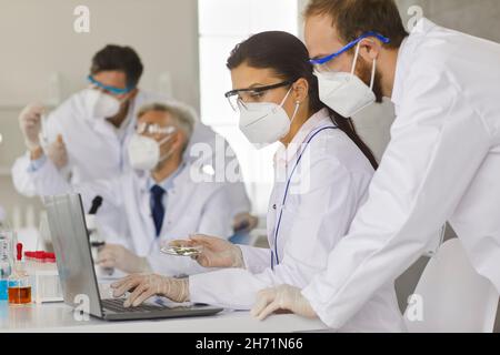 Scientists working together to analyze samples while working in a modern research laboratory. Stock Photo