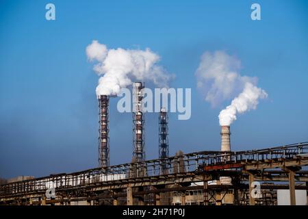 Smoke stack over chemical plant on blue sky background Stock Photo