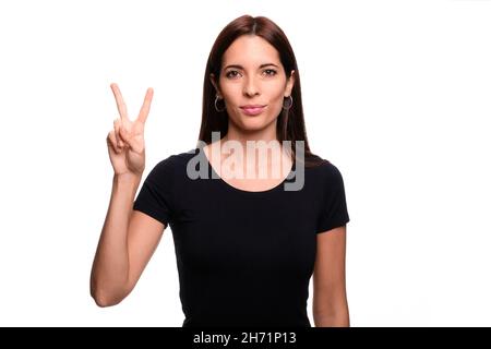 Isolated in white background brunette woman saying letter U in spanish sign language Stock Photo