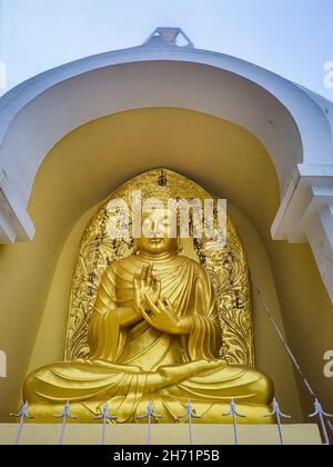 meditating buddha golden statue from low angle at monastery at morning image is taken at japanese temple shanti stupa darjeeling west bengal india. Stock Photo