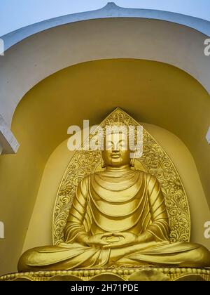 meditating buddha golden statue from low angle at monastery at morning image is taken at japanese temple shanti stupa darjeeling west bengal india. Stock Photo