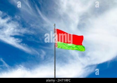Flag of Belarus waving against blue sky with clouds Stock Photo