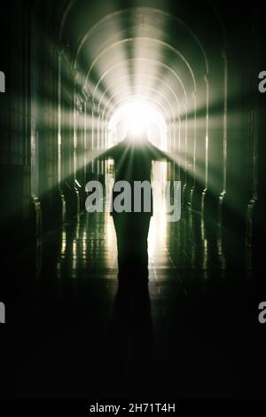 woman in a cross-coat. Rays of light coming out of the head. Stock Photo