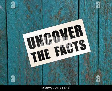 Uncover the Facts card on wooden background. Social concept. Business concept Stock Photo