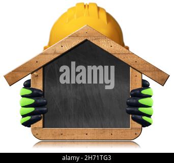 Manual worker with a safety helmet and work gloves holding a blank chalkboard in the shape of a wooden house, isolated on white with copy space. Stock Photo