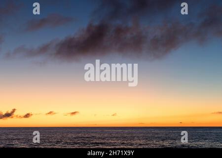 Colorful sunset over calm sea water near tropical beach. Summer vacation concept. Flores island, Azores archipelago, Portugal, Europe Stock Photo