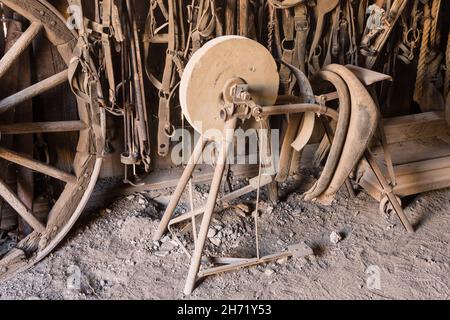 A foot-powered knife-sharpening stone grinding wheel in the blacksmith shop in the old ghost town of Shakespeare, New Mexico. Stock Photo