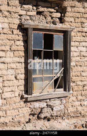 A window in the adobe brick wall of the Grant House, the stagecoach station in the old ghost town of Shakespeare, New Mexico. Stock Photo