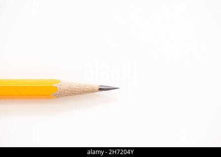 Close up details of sharpened yellow pencil isolated over white background Stock Photo