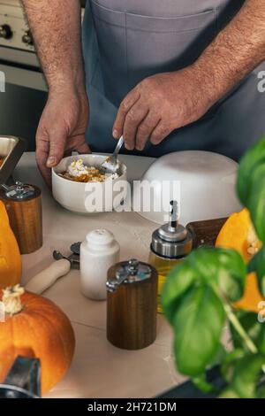 Staying at home and cooking. Homemade Italian pumpkin ricotta ravioli. Men making pumpkin ricotta filling for ravioli. Stock Photo