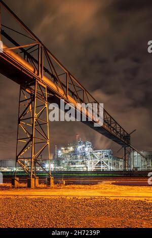 Metal construction with pipeline overpass at night in Port of Antwerp Stock Photo