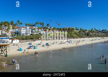 San Clemente, CA, USA – November 13, 2021: People on a beach with white buildings in the background in San Clemente, California. Stock Photo