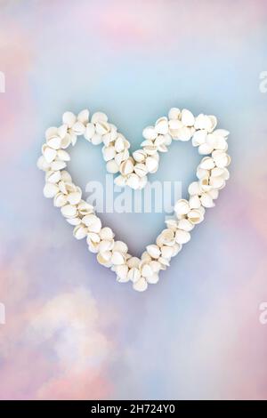 Cockleshell heart shaped seashell wreath on sky cloud heavenly background. Symbol of love for Valentines Day, Mothers Day, birthday greeting card.