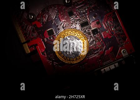 Bitcoin coin on a red video card background. Cryptocurrency, virtual money. Blockchain technology, bitcoin mining concept Stock Photo