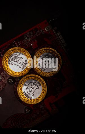 Bitcoin coin on a red video card background. Cryptocurrency, virtual money. Blockchain technology, bitcoin mining concept Stock Photo