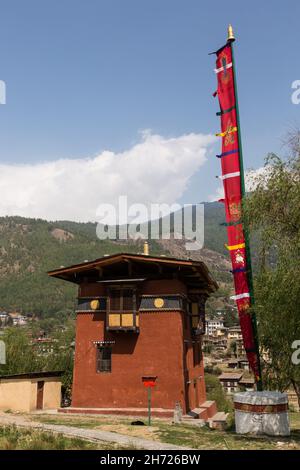 A prayer flag and the Gyenay Lhakhang Monastery in Thimphu, Bhutan. Stock Photo