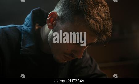 Close up of young blacksmith man doing sandpaper with sanding stick Stock Photo