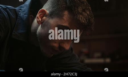 Close up of young blacksmith man doing sandpaper with sanding stick Stock Photo
