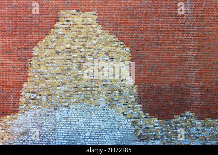Close-up of a brick wall where new brick has been used around the remains of the old brick to restore the building. Stock Photo