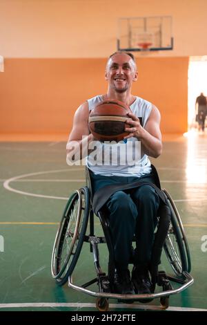 a photo of a war veteran playing basketball in a modern sports arena. The concept of sport for people with disabilities Stock Photo
