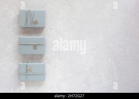 grey Christmas gift boxes decorated with snowflakes on grey background, top view, copy space Stock Photo