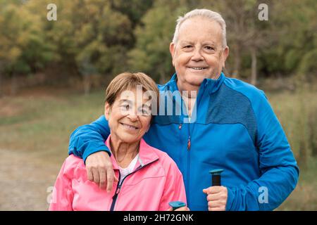 Happy senior couple trekking and having fun in the woods - Elderly travel vacation Stock Photo