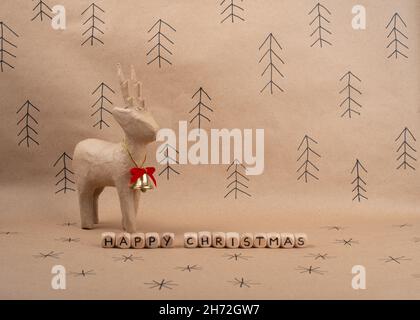Hand made deer and greeting on brown paper. Minimal eco Christmas concept. Stock Photo