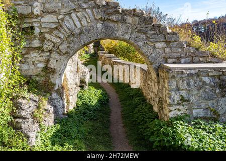 Big walls of an old castle ruin and a high gate made of stone Stock Photo