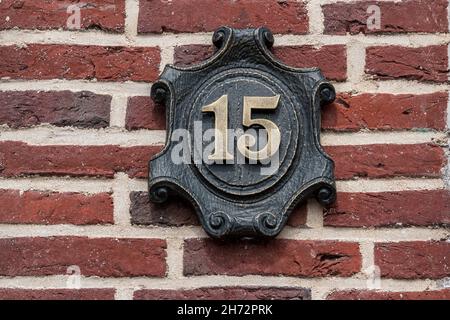 House number made of metal on a brick wall Stock Photo