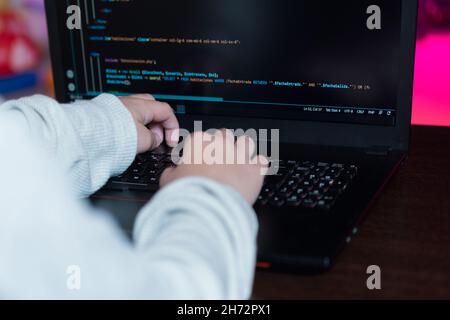 Teenager writing code programming a web page to do her homework as a programmer. Stock Photo
